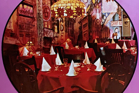 Ed's Warehouse interior dining room. Round tables with red tablecloths and white napkins.