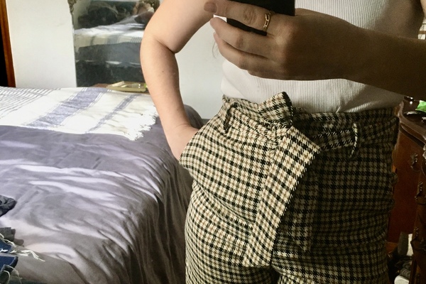 woman poses with high waisted checked print pants.