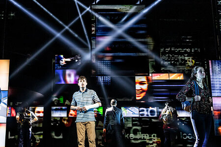 Evan Hansen stands on stage wearing the iconic striped tee and beige pants