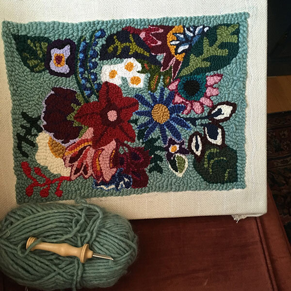 Punch needle pillow in progress. Various flowers of different colours.