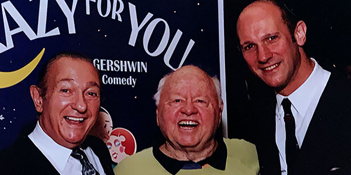 Ed Mirvish with Mickey Rooney and David Mirvish stand in front of signage for Crazy for You.