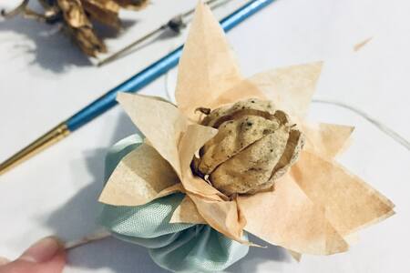 Close up of paper flower with dried cone in the centre.