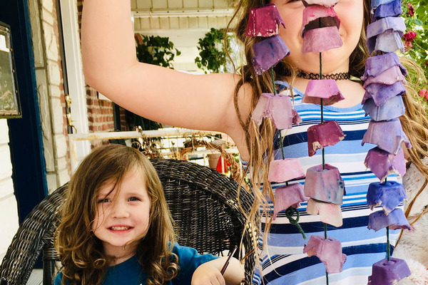 2 children hold up egg carton craft