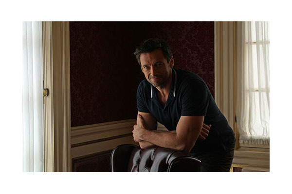 Hugh Jackman leaning on the back of a chair in the Royal Alex lounge