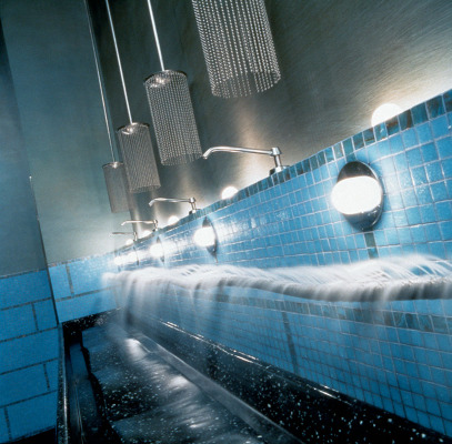 Tiny jets of water stream from an undulating pipe stretching the length of the communal sinks in the washroom.  Interior of theatre with boxes Photo by Evan Dion  The sculpted frieze of the boxes reflects the shapes and forms of Stella's murals.  Fra