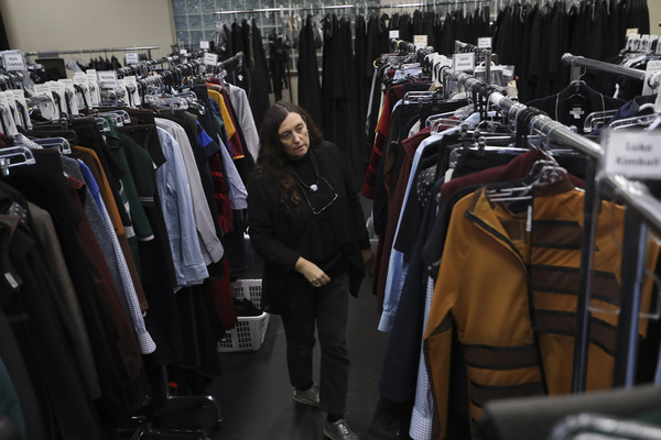 Costume Designer Katrina Lindsay looks through racks of costumes 